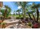 Serene backyard oasis featuring a patio, palm trees, and landscaped garden with red flowers at 7425 E Gainey Ranch Rd # 13, Scottsdale, AZ 85258