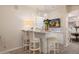 Home wet bar featuring a white marble countertop with seating and decorative pendant lights at 7425 E Gainey Ranch Rd # 13, Scottsdale, AZ 85258