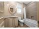 Neutral bathroom featuring a granite countertop vanity with a round wood-framed mirror and a shower and tub combo at 7425 E Gainey Ranch Rd # 13, Scottsdale, AZ 85258
