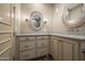 Bathroom with double sink vanity, granite countertops, wood framed mirrors, and neutral walls at 7425 E Gainey Ranch Rd # 13, Scottsdale, AZ 85258