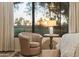 Cozy bedroom featuring a sitting area with chair overlooking outdoor scenery at 7425 E Gainey Ranch Rd # 13, Scottsdale, AZ 85258