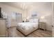 Comfortable bedroom with a tray ceiling, wood-look floors, shutters, decorative wall art and luxury bedding at 7425 E Gainey Ranch Rd # 13, Scottsdale, AZ 85258