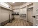 Walk-in closet with organized shelving, hanging rods, wood-look tile flooring, and a rolling ladder at 7425 E Gainey Ranch Rd # 13, Scottsdale, AZ 85258