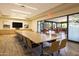 Conference room with a large table and chairs, TV, and glass doors leading to outdoor area at 7425 E Gainey Ranch Rd # 13, Scottsdale, AZ 85258