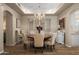 Formal dining room with a chandelier, wood floors, and a large window with shuttered blinds at 7425 E Gainey Ranch Rd # 13, Scottsdale, AZ 85258