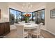 Bright dining area with a bay window offering scenic views, hardwood floors, and a modern chandelier at 7425 E Gainey Ranch Rd # 13, Scottsdale, AZ 85258