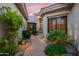 Inviting entrance with lush landscaping, rock features, and a well-lit pathway to the front door at 7425 E Gainey Ranch Rd # 13, Scottsdale, AZ 85258