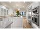 Modern kitchen with white cabinets, marble countertops, stainless steel appliances, and a large kitchen island at 7425 E Gainey Ranch Rd # 13, Scottsdale, AZ 85258