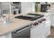 Kitchen island featuring marble countertops, a cooktop with red knobs, and stainless steel drawer features at 7425 E Gainey Ranch Rd # 13, Scottsdale, AZ 85258