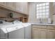 Spacious laundry room with a white washer and dryer and a sink with extra storage at 7425 E Gainey Ranch Rd # 13, Scottsdale, AZ 85258