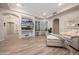 Comfortable living room featuring recessed lighting, wood-look tile flooring, custom built-in shelving, and a neutral-colored sofa at 7425 E Gainey Ranch Rd # 13, Scottsdale, AZ 85258