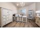 Bright office with light wood floors, large desk, white cabinets, and a decorative chandelier at 7425 E Gainey Ranch Rd # 13, Scottsdale, AZ 85258