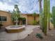 Inviting courtyard with a water fountain and desert landscaping with cacti and palm trees at 7816 N 47Th St, Paradise Valley, AZ 85253