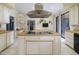Modern kitchen features stainless steel hood vent, cooktop, island, and adjacent dining area at 7816 N 47Th St, Paradise Valley, AZ 85253