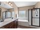 Well-lit bathroom featuring dual sinks, a glass block window and glass enclosed shower at 799 W Press Rd, San Tan Valley, AZ 85140