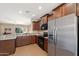 Well-equipped kitchen showcasing stainless steel appliances, stone countertops, and dark wood cabinets at 799 W Press Rd, San Tan Valley, AZ 85140