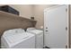 Bright laundry room with Whirlpool washer and dryer and practical shelving for storage at 799 W Press Rd, San Tan Valley, AZ 85140