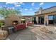 Backyard area with a cozy outdoor fireplace, string lights, a built-in grill, and a concrete patio at 9280 E Thompson Peak Pkwy # 39, Scottsdale, AZ 85255