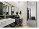 Modern bathroom with dual sinks, sleek black cabinets, and glossy black tiled accent wall at 9280 E Thompson Peak Pkwy # 39, Scottsdale, AZ 85255
