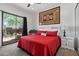 Cozy bedroom with red bedding, large window view to landscaped backyard and decorative accents at 9280 E Thompson Peak Pkwy # 39, Scottsdale, AZ 85255