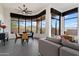 Open living room with scenic views from the large, curved windows and a stylish ceiling fan at 9280 E Thompson Peak Pkwy # 39, Scottsdale, AZ 85255