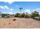 Gravel backyard with some bushes and several outbuildings in the distance at 9347 E Edgewood Ave, Mesa, AZ 85208
