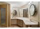 Bathroom with dual sinks, cabinets, mirrors, and vanity lighting at 9347 E Edgewood Ave, Mesa, AZ 85208
