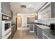 Galley kitchen with stainless steel appliances, gray cabinets, and vinyl flooring at 9347 E Edgewood Ave, Mesa, AZ 85208