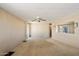 Cozy carpeted living room with a ceiling fan and sliding glass door at 9347 E Edgewood Ave, Mesa, AZ 85208