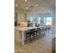 Open kitchen with white cabinets, island with seating and a dining area with large windows at 1185 E Gleneagle Dr, Chandler, AZ 85249