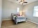 Comfortable bedroom features ceiling fan, wood-look floors and a bright window at 11934 S 181St Ave, Goodyear, AZ 85338