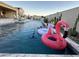 Inviting pool featuring colorful floaties, lounge chairs, patio seating, and water feature, perfect for outdoor relaxation at 11934 S 181St Ave, Goodyear, AZ 85338