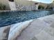 Sparkling pool featuring rock waterfall accents and travertine coping at 11934 S 181St Ave, Goodyear, AZ 85338