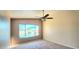 Carpeted bedroom featuring a ceiling fan and a window overlooking the pool at 14748 W Willow Ln, Surprise, AZ 85374
