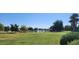 Scenic golf course view featuring a lake with fountains, lush green lawns, and mature trees at 14748 W Willow Ln, Surprise, AZ 85374