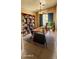 Functional home office with a large desk, bookshelves, and a comfortable chair at 14748 W Willow Ln, Surprise, AZ 85374