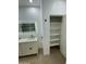 Bathroom featuring double vanity with bronze fixtures and closet with shelving at 15864 S Cherry Hills Dr, Arizona City, AZ 85123