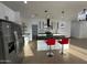 Open-concept kitchen with an island, stainless steel refrigerator, and pendant lighting at 15864 S Cherry Hills Dr, Arizona City, AZ 85123