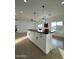 Bright open kitchen with island seating, modern light fixtures, and plenty of natural light at 15864 S Cherry Hills Dr, Arizona City, AZ 85123