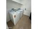Functional laundry area with tile floors, new washer, new dryer and overhead shelf at 15864 S Cherry Hills Dr, Arizona City, AZ 85123