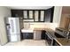 A modern kitchen featuring stainless steel appliances, black cabinets, and a farmhouse sink at 1846 E Intrepid Ave, Mesa, AZ 85204