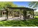 Community area with shaded pergola, stone pillars, swings, and bench seating at 20084 N 103Rd St, Scottsdale, AZ 85255