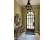 Bright entry foyer with stone floors, arched windows, and a decorative light fixture at 20084 N 103Rd St, Scottsdale, AZ 85255