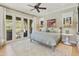 Bright bedroom with hardwood floors, ceiling fan, French doors, and views of outdoor space at 20084 N 103Rd St, Scottsdale, AZ 85255