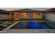 A backyard pool with LED lighting offers a refreshing escape, beautifully reflecting the home's exterior at dusk at 22849 E Marsh Rd, Queen Creek, AZ 85142
