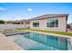 A sparkling pool surrounded by travertine decking, with a covered patio, offers a luxurious outdoor experience at 22849 E Marsh Rd, Queen Creek, AZ 85142