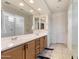 Bright bathroom featuring double sinks, a large mirror, wooden cabinets, and modern fixtures at 22849 E Marsh Rd, Queen Creek, AZ 85142
