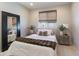 This bedroom boasts neutral walls, wood blinds, carpet floors, and bed with throw blanket and pillows at 22849 E Marsh Rd, Queen Creek, AZ 85142