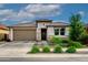 A beautiful single-story home with desert landscaping, stone accents, and a modern garage door under a sunny sky at 22849 E Marsh Rd, Queen Creek, AZ 85142