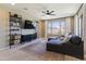 Cozy living room with a large sectional, custom shelving, and bright windows offering outdoor views at 22849 E Marsh Rd, Queen Creek, AZ 85142